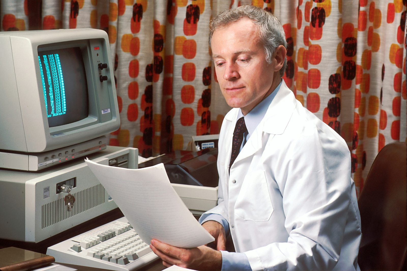 Arzt liest einen Ausdruck am Computer